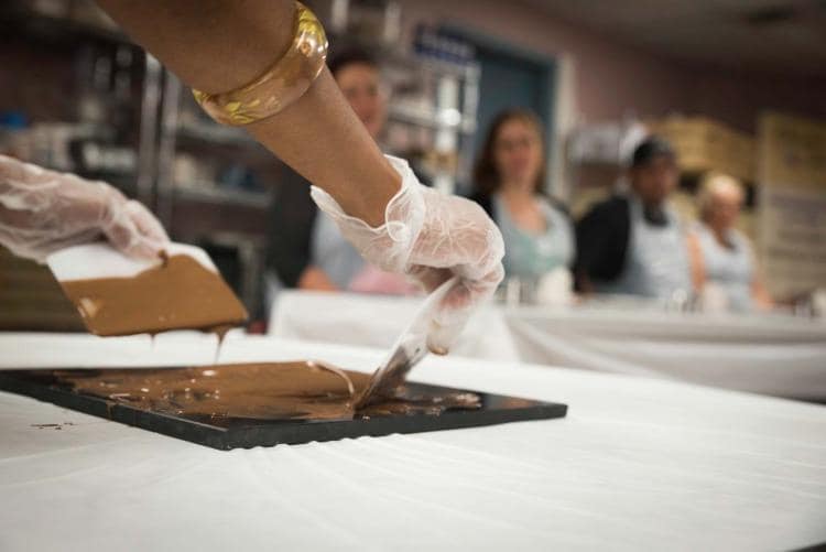 Hands-on chocolate tempering class in Hamilton with guests learning tabling and molding techniques at Chocolate Tales