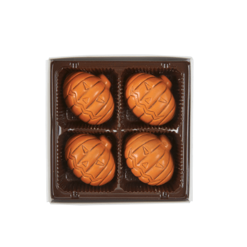4 piece Pumpkin spice truffles from chocolate tales. 4 pumpkin shaped truffles are placed in a plastic container.